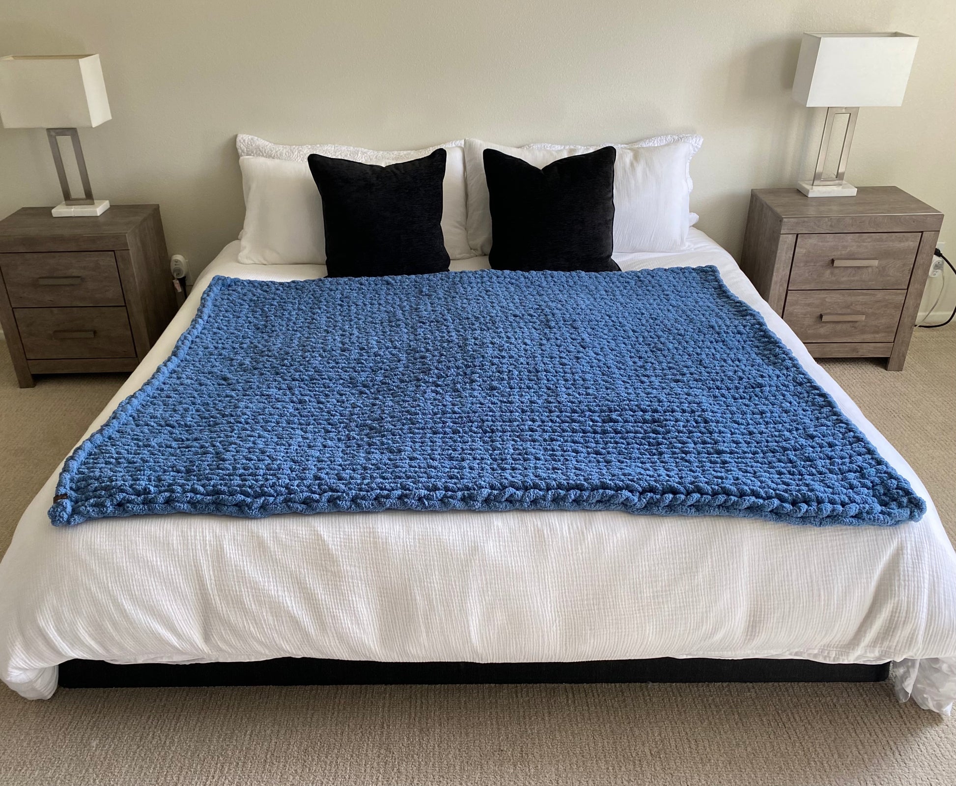 Medium chunky knit blanket in Cold Sea on a king sized bed